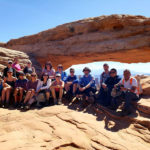 Large hiking group mid afternoon at Mesa Arch