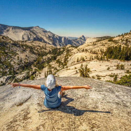 Excited woman hiker sitting down in Yosemite National Park
