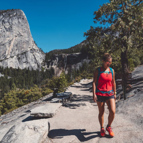 Women hiking on granite with Yosemite dome in background